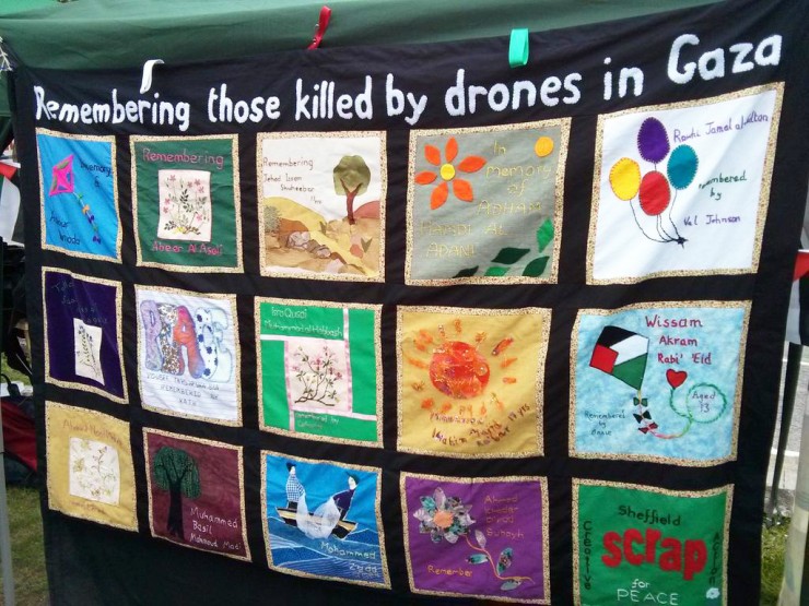 A quilt with illustrated patches entitled "Remembering those killed by drones in Gaza"