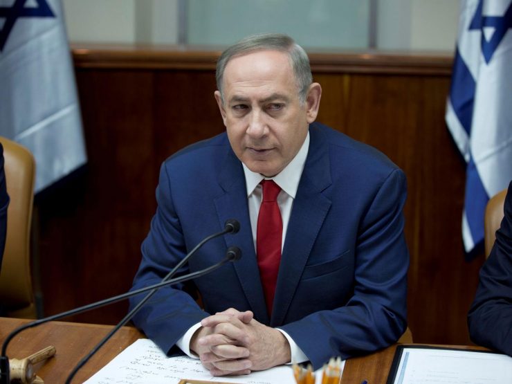 Benjamin Netanyahu seated behind a desk